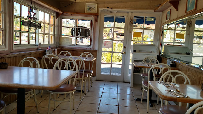 Cozy interior dining room at Sugar Shack Cafe with wood tables, bentwood chairs and lace-curtained windows