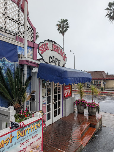 Sugar Shack Cafe storefront on El Camino Real on an overcast day, with the East Burritos sandwich board out front
